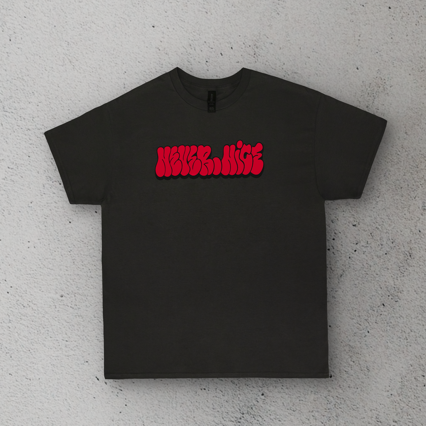 Black t-shirt with red text on a gray concrete surface